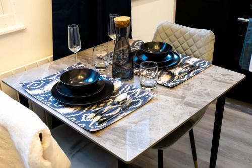 利兹Kirkgate Suites - Signature Suite的一张带盘子和玻璃杯的桌子和一瓶葡萄酒
