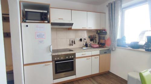 格尔洛斯贝格Apartment Rahm的厨房配有白色橱柜和冰箱。