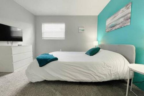 圣徒皮特海滩Madeira Beach 2 bedroom Waterfront Condo With Dock的卧室配有白色大床和蓝色的墙壁