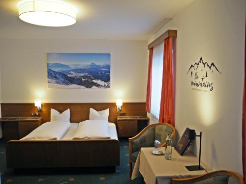 蒂罗尔-泽费尔德伊格特霍夫酒店的酒店客房配有一张床铺和一张桌子。