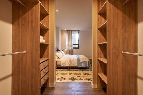 奇亚Caluce Apt 5D by Letoh的一间卧室配有木制橱柜和一张位于客房内的床。