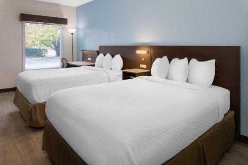 杰克逊维尔杰克逊维尔/勒琼营贝蒙特旅馆套房酒店的酒店客房设有两张床和窗户。
