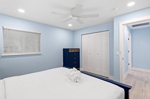 萨尼贝尔Caloosa Cottage at Palm View Inn of Sanibel with Bikes的一间卧室配有一张带蓝色墙壁的大床