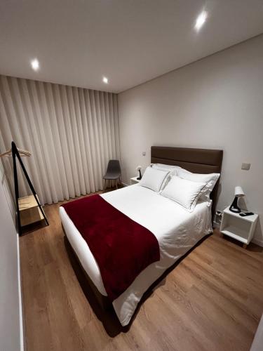 阿鲁卡Arouca Guest House 2的一间卧室配有一张带红色毯子的大床