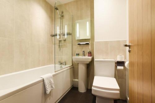 朴次茅斯Location City Centre Great access的浴室配有卫生间、浴缸和水槽。