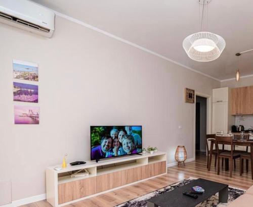 都拉斯Loris Apartaments 205的客厅配有白色墙壁上的平面电视。