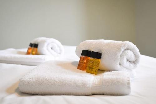SouthbourneCosy One Bed Bungalow Style Annex的床上的毛巾和一瓶肥皂