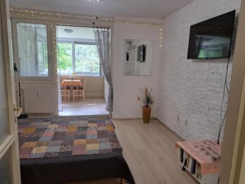 加尔多尼Szoba kilátással apartman的客厅设有床铺和墙上的电视