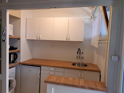 加尔多尼Szoba kilátással apartman的小厨房配有白色橱柜和水槽