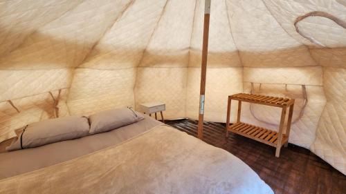 纳塔列斯港Glamping Río Serrano - Caja Los Andes的一个带一张床和一张桌子的大帐篷