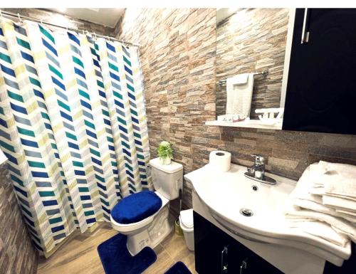 Ensanche Vista AlegreJC. Caribe Aparta Hotel…的浴室设有蓝色的卫生间和水槽。