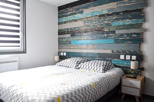 鲁昂Eco-Appart'hôtel Rouen -- BDE的一间卧室设有一张床和木墙