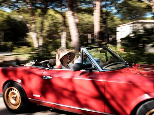 Narbolia伊斯阿里纳斯度假酒店的女人驾驶一辆红色的可转换汽车