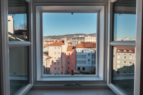 的里雅斯特Le Finestre Boutique Apartments的享有城市美景的开放式窗户。