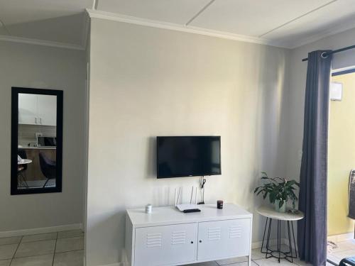 肯普顿帕克Greenpark Apartment的一间客厅,在白色的墙上配有电视
