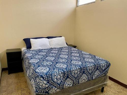 危地马拉Casa Quetzal的一间卧室配有一张带蓝色和白色棉被的床