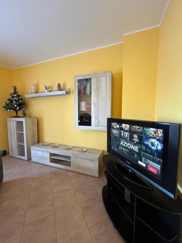 博洛尼亚Cà Savoia的客厅配有平面电视和黄色墙壁。
