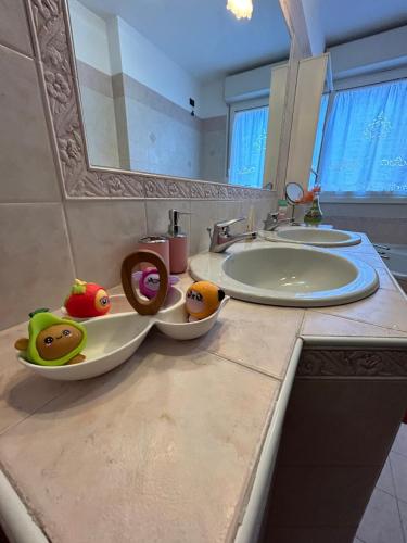 博洛尼亚Cà Savoia的浴室柜台设有两个水槽和两碗水果