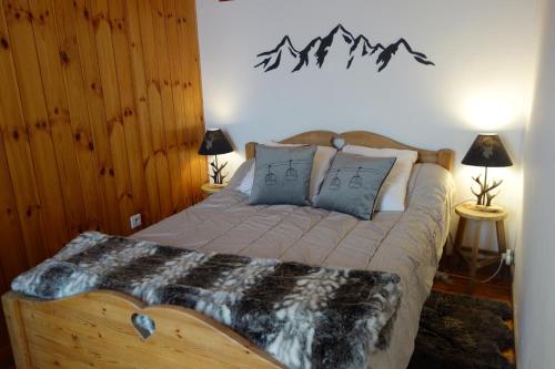 布里昂松Appartement cosy montagne, centre ville de Briançon的一间卧室配有一张带两盏灯和两张桌子的床。