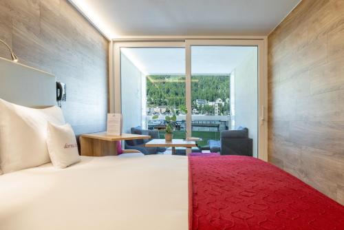 圣莫里茨Hotel Sonne St. Moritz 3* Superior的酒店客房设有一张床和一个大窗户