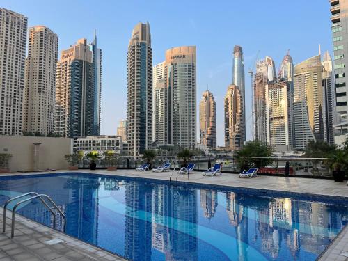 迪拜Amazing 1 bedroom apt in Marina的一座位于城市的游泳池,有高大的建筑