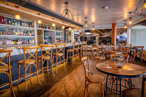 伊基克Hotel Gavina Costa Mar的一间带桌椅的餐厅和一间酒吧