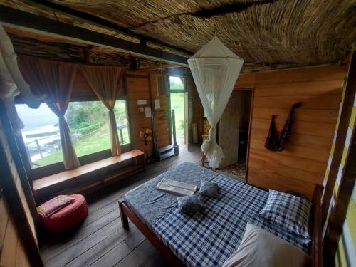 圣多美GENTE D'AQUI Ngê D'ai êê的一间设有床铺的卧室,位于带窗户的房间内