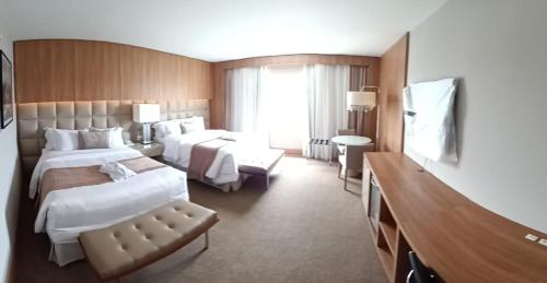 库里提巴White Plaza Hotel的酒店客房设有两张床和电视。
