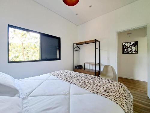 戈亚斯州上帕莱索Casa dos Lírios的卧室配有白色的床和窗户。