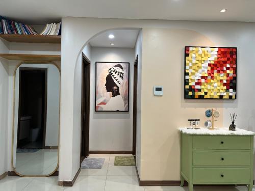 胡志明市UPhoenix Home- HaDo Centrosa Garden的浴室设有绿色梳妆台和墙上的绘画作品