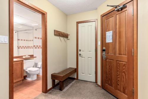惠斯勒Cascade Lodge suite GENIUS SPECIAL WIFI cable HDTV Whistler Village air conditioning heating heated underground pay parking pool 2 hot tubs sauna gym的一间带卫生间和木门的浴室