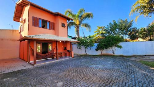 皮涅拉Partiu Praia SC- Pinheira的一座橙色的房子,前面设有一个庭院