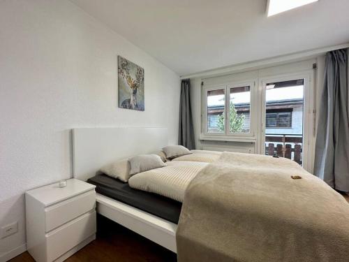 塔什Panorama apartment for 4 near Zermatt的白色的卧室设有床和窗户