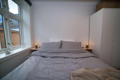 卑尔根Vestre Murallmenningen的白色客房的一张床位,设有两个窗户