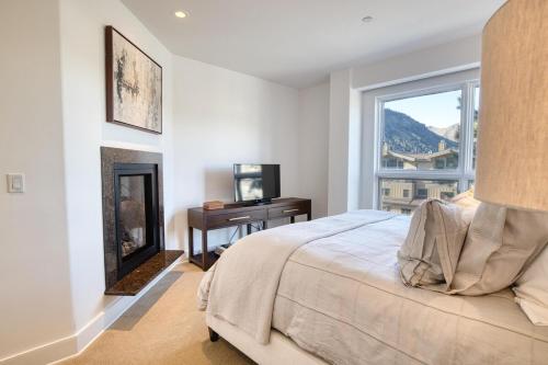凯彻姆Luxe Ketchum Penthouse with Rooftop Hot Tub的一间卧室配有一张床、一个窗口和一张书桌