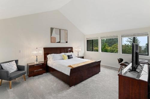 贝尔维尤Highland Haven BY Betterstay的一间卧室配有一张床、一台电视和一把椅子