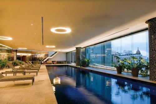 墨西哥城AMAZING REFORMA APARTMENT, 2 brms 2 bath, AWESOME的一座带大窗户的建筑中的游泳池