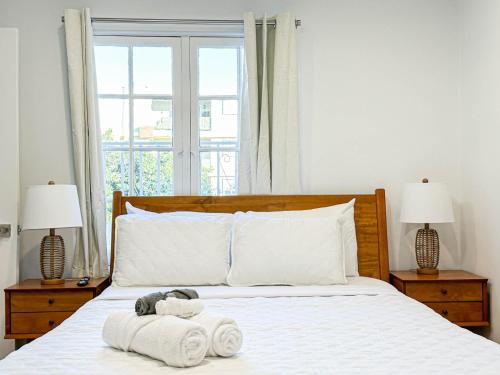 洛杉矶Modern 2-Bedroom Gem Close to Beverly Hills - DOH2的一间卧室配有一张带毛巾和两盏灯的床。
