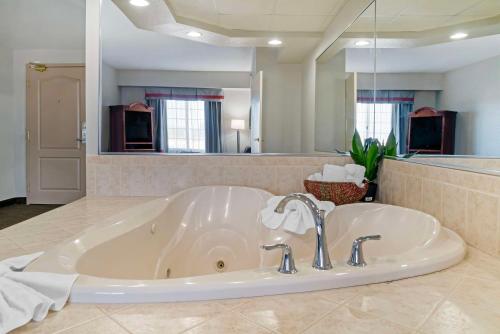 大急流城大瀑布城贝斯特韦斯特行政套房酒店的浴室内设有一个带水槽的大浴缸