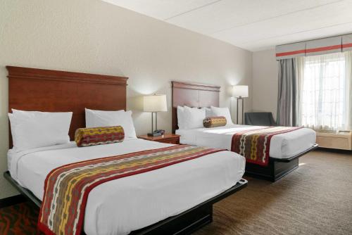 大急流城大瀑布城贝斯特韦斯特行政套房酒店的酒店客房设有两张床和两盏灯。