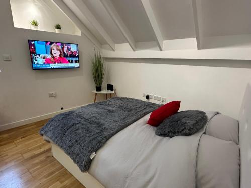 直布罗陀Moda Gibraltar - Central Location的卧室配有一张壁挂式平面电视的床。