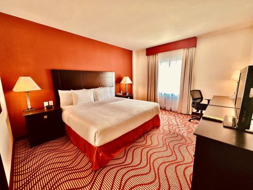 圣路易斯波托西La Quinta by Wyndham San Luis Potosi的酒店客房,配有床和电视