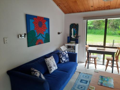 上哈特Akatarawa Valley Retreat a Cosy Two Bedroom Guest Suite的客厅配有蓝色的沙发和桌子