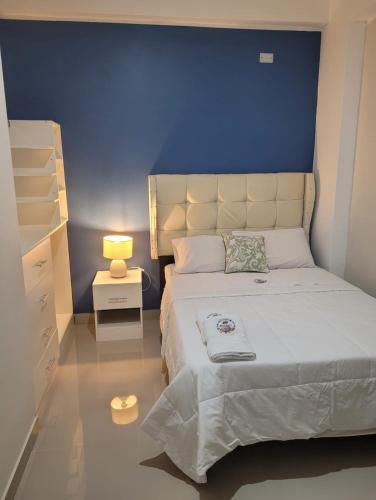 皮斯科CASA MARIA的一间卧室设有一张蓝色墙壁的大床