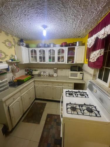 金斯敦Jamaican J Home的厨房配有白色橱柜和炉灶烤箱。