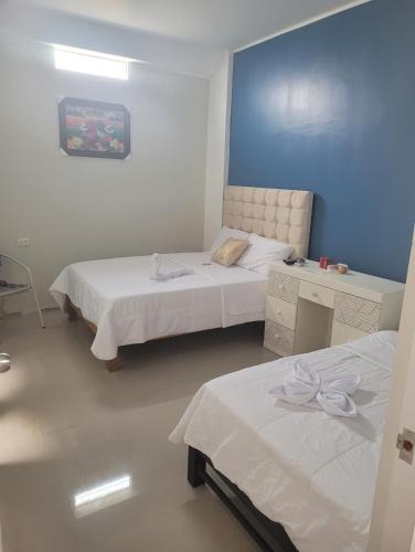 皮斯科CASA MARIA的一间卧室设有两张床和蓝色的墙壁