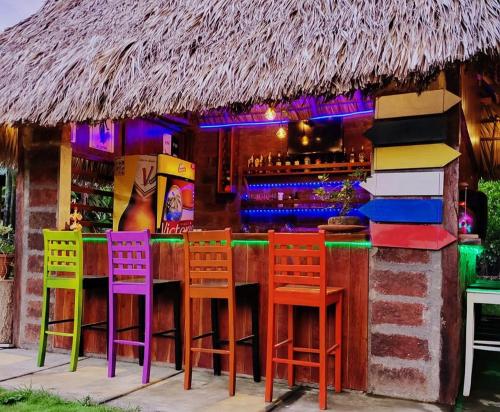 莫约加尔帕Hostal Casa Mauro的酒吧前的酒吧,带五颜六色的椅子