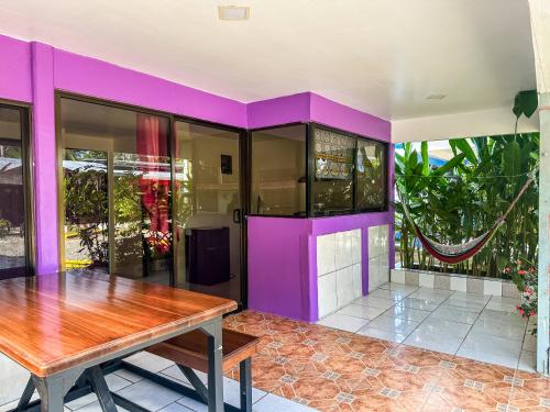 别霍港Casitas Coloradas Puerto Viejo的一间拥有紫色墙壁和木桌的用餐室