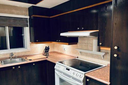 拉瓦尔Ahava, Centropolis Laval的厨房配有水槽和炉灶 顶部烤箱