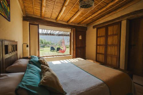 蒂尔卡拉卡瓦尼亚斯阿加坎托山林小屋的一张大床,位于带大窗户的房间里